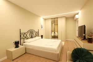 a bedroom with a large bed and a television at Grandstay Apartments in Durrës
