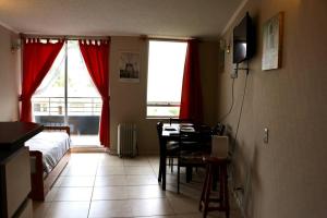 a bedroom with a bed and a table and a desk at Confortable depto. en La Serena in La Serena