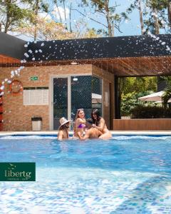 un grupo de personas sentadas en una piscina en Libertg Hotels Spa, en Copacabana
