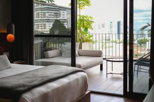 a hotel room with a bed and a balcony at Hotel Sexto by Icono in Armenia +68 photos