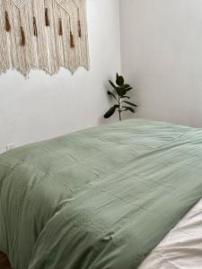 1 dormitorio con 1 cama con edredón verde en Hemingway by Luca - Free Parking, en Los Ángeles