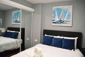 a bedroom with two beds with blue pillows and a mirror at Hotel Boutique Calizo vip in Fajardo