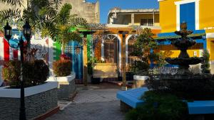 a courtyard with a fountain and some buildings at Hotel Boutique Calizo vip in Fajardo