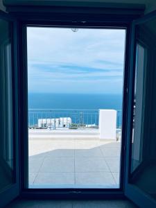 une fenêtre ouverte avec vue sur l'océan dans l'établissement Aegean Mirror, Andros, à Apróvaton