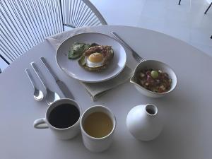 una mesa con un plato de comida y tazas de café en Hotel Boutique Casa Lulu en Mazatlán