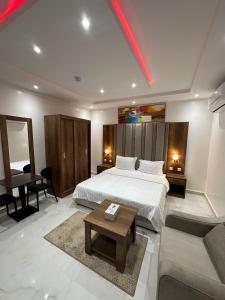a bedroom with a bed and a couch and a table at ليوان الريان للشقق المخدومة Liwan Al-Rayyan for serviced apartments in Riyadh +31 photos