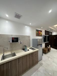 a kitchen with a sink and a refrigerator at ليوان الريان للشقق المخدومة Liwan Al-Rayyan for serviced apartments in Riyadh