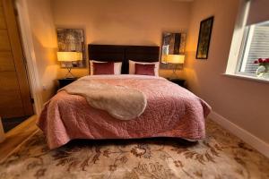 a bedroom with a large bed and two lamps at Modern country charm apartment. in Mullingar
