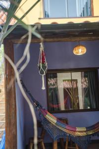 a hammock in front of a room with a mirror at Pousada Cipó Prata in Serra do Cipo