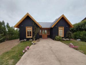 a black house with a driveway in front of it at Doña Hilaria in El Calafate