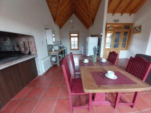 a kitchen and dining room with a wooden table and chairs at Doña Hilaria in El Calafate