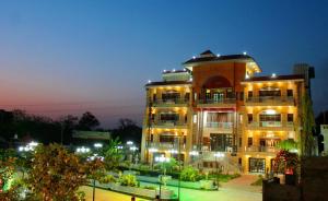 a large building with lights on it at night at Rajeshwari Resort in Udaipur