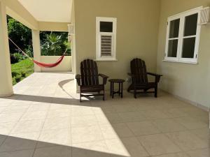 2 sillas y una mesa en el patio en Aruanda Apartment - perfect get-away for two at the top of Bequia, en Union
