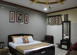 a bedroom with a bed and a chair at Rajeshwari Resort in Udaipur +11 photos