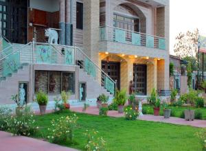 a building with stairs and plants in a yard at Rajeshwari Resort in Udaipur