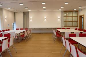 a classroom with tables and chairs and a whiteboard at Landhotel Steigenhaus in Untermünkheim