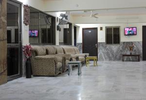 a waiting room with couches and tables and televisions at Rajeshwari Resort in Udaipur