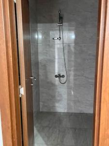 eine Dusche in einem Badezimmer mit einer Glastür in der Unterkunft Двуспален апартамент в к-с Пирин Палас in Bansko