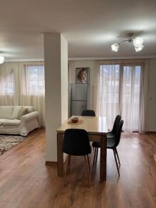 ein Wohnzimmer mit Esstisch und Stühlen in der Unterkunft Двуспален апартамент в к-с Пирин Палас in Bansko