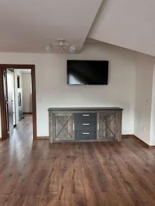 ein Wohnzimmer mit einem Flachbildfernseher an der Wand in der Unterkunft Двуспален апартамент в к-с Пирин Палас in Bansko