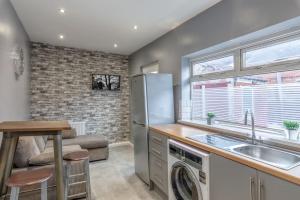 a kitchen with a washer and dryer next to a window at Town Centre Town House free WiFi and free on street parking in Middlesbrough