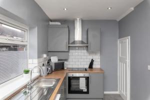 a kitchen with a sink and a stove at Town Centre Town House free WiFi and free on street parking in Middlesbrough
