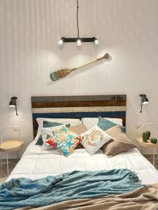 a bed with two pillows and a baseball bat on the wall at Eraclea Minoa Village in Montallegro