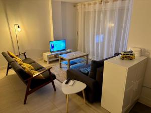 salon z kanapą i telewizorem w obiekcie La résidence la Pomme de Pin - Vieux-Boucau-les-Bains - 3 pièces, 6 personnes w mieście Vieux-Boucau-les-Bains