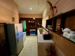 cocina con nevera y suelo de baldosa. en Casa Pochotal, en Cartagena