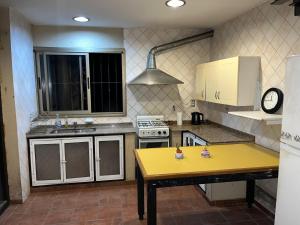 a small kitchen with a yellow table in it at La posada del Colibrí in Mendoza