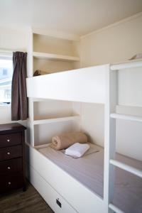 - un lit superposé blanc dans une chambre dans l'établissement Mercury Bay Holiday Park, à Whitianga
