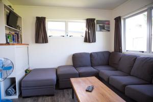 a living room with a couch and a table at Mercury Bay Holiday Park in Whitianga