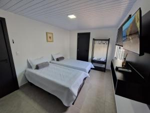 Schlafzimmer mit einem Bett und einem Flachbild-TV in der Unterkunft Condomínio Inn The Studio in Foz do Iguaçu