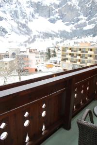 uma varanda com vista para uma montanha coberta de neve em Grichting Hotel & Serviced Apartments em Leukerbad