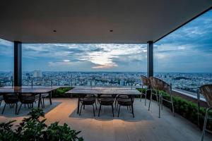 a patio with tables and chairs and a view of a city at The Rixx Trendy Apartmen 2bed 1bath at The Marq in Ho Chi Minh City