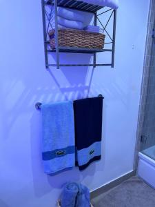 baño con toallas azules colgadas en un estante en Hemingway by Luca - Free Parking, en Los Ángeles