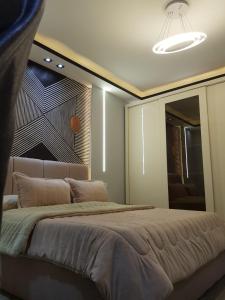 een slaapkamer met een groot bed en een grote spiegel bij الجيزه شارع كليه الزراعه عماره ١٢ in Caïro