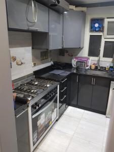 een keuken met een kookplaat en een oven bij الجيزه شارع كليه الزراعه عماره ١٢ in Caïro