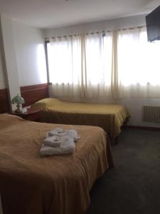 2 letti in camera d'albergo con asciugamani di Hotel Alvear Jujuy a San Salvador de Jujuy