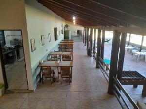 an empty restaurant with wooden tables and chairs at Hotel Fazenda Recanto do Monte Alegre in Piraju