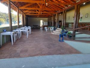 uma sala com mesas e mesas e cadeiras brancas em Hotel Fazenda Recanto do Monte Alegre em Piraju