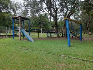 a playground with two slides in a park at Hotel Fazenda Recanto do Monte Alegre in Piraju