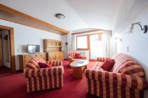 ein Wohnzimmer mit 2 Stühlen und einem Tisch in der Unterkunft Appartement Christian in Maurach