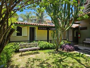 un banco del parque frente a una casa en Pousada Casa Centro Búzios, en Búzios