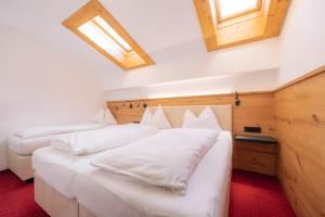 2 camas en una habitación con sábanas blancas en Appartement Christian en Maurach