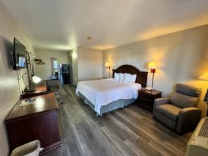 Habitación de hotel con cama y silla en Days Inn by Wyndham Van Horn TX, en Van Horn