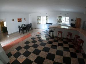 a room with a checkered floor with chairs and a kitchen at Jacobsen Bungalow in Maun, Boronyane in Maun
