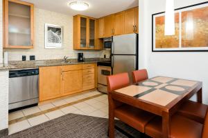 a kitchen with wooden cabinets and a wooden table at Residence Inn Florence in Florence