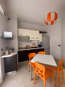 een keuken met een tafel en een aantal oranje stoelen bij La Casa di Cristina in Leinì