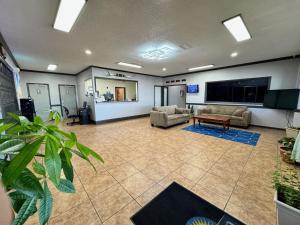 a large room with couches and a flat screen tv at Days Inn by Wyndham Van Horn TX in Van Horn